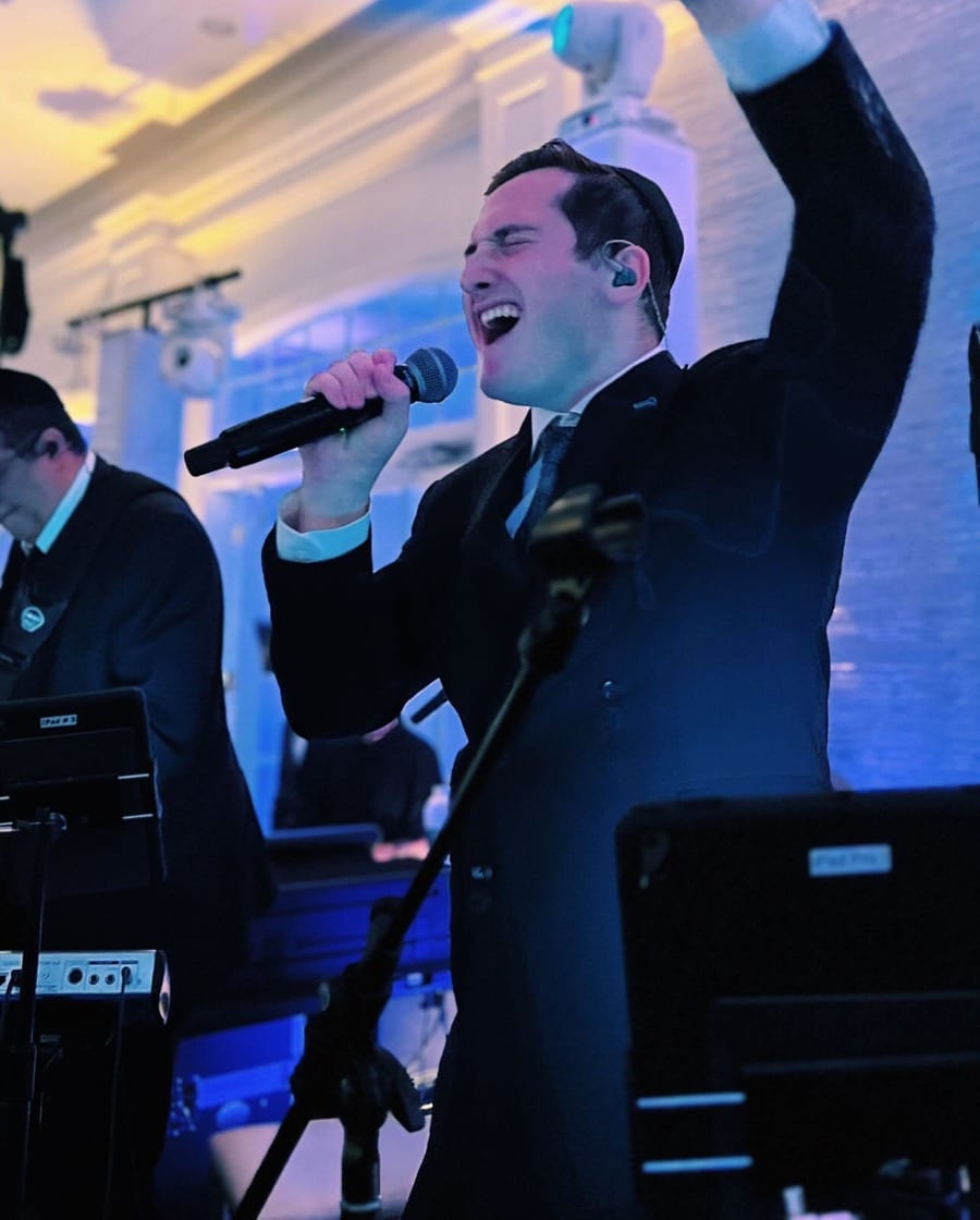 Dovid Pearlman singing to a packed dance floor
